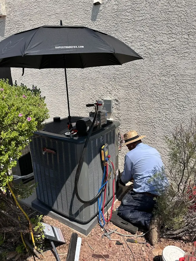 HVAC technician performing outdoor AC maintenance in Ripon