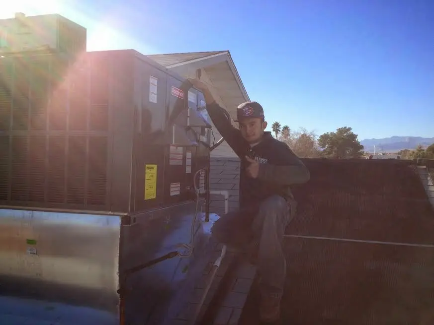 HVAC technician performing Air Duct Repair on a rooftop unit in Ripon